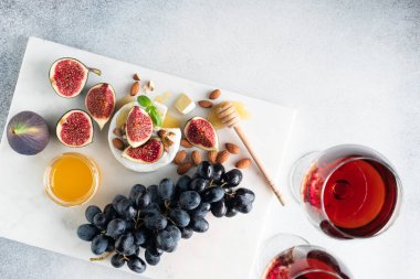 Beyaz arka planda üzümlü, incirli, fındıklı ve şaraplı Camembert peyniri. Şarap takımı.