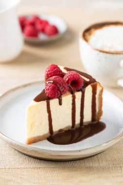 Slice of cheesecake with chocolate sauce clipart