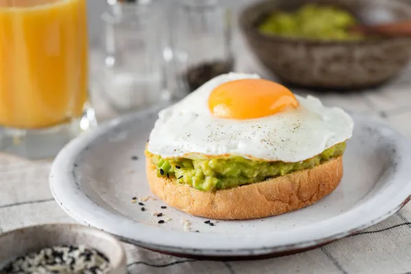 Бутерброд зі сніданком авокадо зі смаженим яйцем — стокове фото