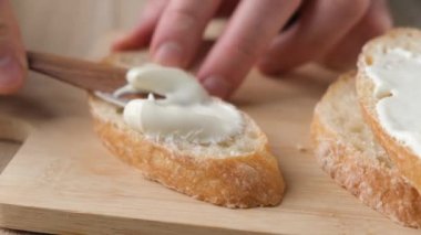 Ekmek dilimine tereyağı sürüyorum. Yakın çekim görüntüsü. Ekmek ve tereyağı