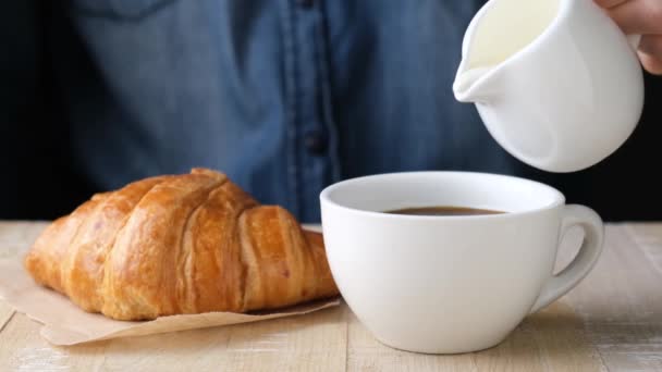 Versare Latte Nel Caffè Nero Rallentatore Vicino Croissant Con Caffè — Video Stock