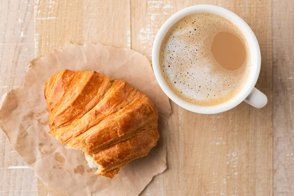 Tazza Caffelatte Bianco Metà Croissant Carta Pergamena Fondo Tavola Legno — Foto Stock