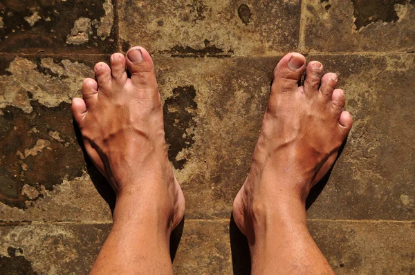 Beton zemindeki Asyalı ayaklarını kapat. Ayaklarının tabanı geniştir çünkü nadiren ayakkabı kullanır.