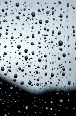 Kara yüzeydeki derin su damlacıkları ve bazı su damlacıkları bulanık.