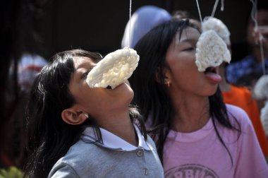 Jakarta, Indonesia - August 17, 2014 : Children taking part in a cracker eating competition at the celebration of Indonesia's independence day in Jakarta