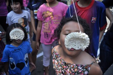 Jakarta, Indonesia - August 17, 2014 : Children taking part in a cracker eating competition at the celebration of Indonesia's independence day in Jakarta