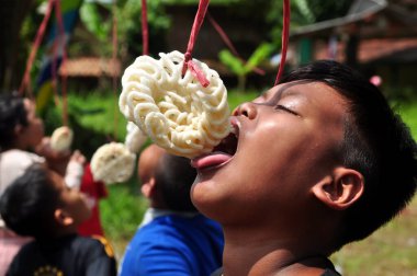 West Java, Indonesia - August 17, 2022: Little child are following the race eating crackers in Indonesia's independence day celebrations at Ciamis, West Java - Indonesia