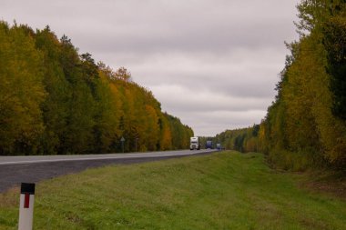 Sonbahar otoyolu boyunca kargo taşıyan kamyonlar. Rusya 'daki Tyumen-Khanty-Mansiysk otoyolunda trafik vardı. Sonbahar yolu.