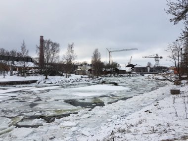 Deniz koyunda buz, yerde kar, Suomenlinna 'da eski binalar ve vinçler, Helsinki.