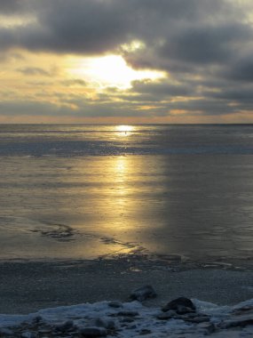 Donmuş Baltık Denizi 'nde güzel bir gün batımı. Suomenlinna, Helsinki' den sarı renkler görünüyor..