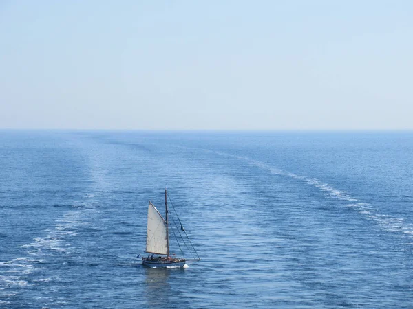 大きな船によって作られた歩道を渡る帆船 — ストック写真