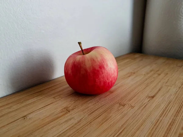 Mela Rossa Gialla Primo Piano Tagliere Legno Contro Parete Bianca — Foto Stock