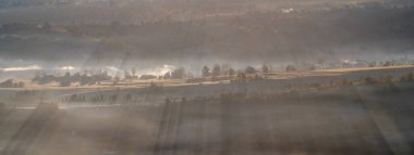 Orta Avrupa 'daki dağ köyü sabah dumanı ve duman odundan ve kömürden geliyor.