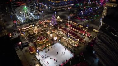 Noel Pazarı, hava manzarası. Noel atlıkarıncaları, buz pateni pisti, büyük bir Noel ağacı ve dönme dolap. Modern bir şehirde aydınlatılmış Noel panayırı.
