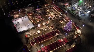 Katowice, Polonya, 3 Aralık 2021. Noel Pazarı, hava manzarası. Noel atlıkarıncaları, buz pateni pisti, büyük bir Noel ağacı ve dönme dolap. Modern bir şehirde aydınlatılmış Noel panayırı.