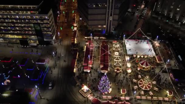 ポーランドのカトヴィツェ 2021年12月3日 クリスマスマーケット 空中ビュー クリスマスのカルーセル アイスリンク 巨大な装飾されたクリスマスツリーと観覧車 現代都市でのイルミネーションクリスマスフェア — ストック動画
