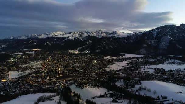 山村での冬の夜 クリスマスの冬の風景 白い山脈とスキーリゾートで覆われたライトアップされた高山市 — ストック動画