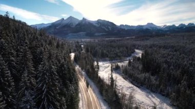 Kışın dağlık yol manzarası. Tatra dağlarında destansı, karlı beyaz kış. Yüksek kayalık dağlar ve temiz yol Polonya 'dan Slovakya' ya uzanan donmuş ormandan geçiyor.