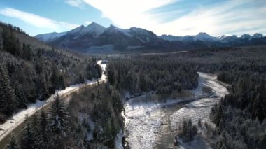 Kışın dağlık yol manzarası. Tatra dağlarında destansı, karlı beyaz kış. Yüksek kayalık dağlar ve temiz yol Polonya 'dan Slovakya' ya uzanan donmuş ormandan geçiyor.