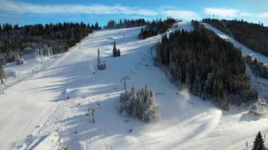 Kışın ünlü bir kayak merkezi, hava manzaralı. Kayak pisti ve yamaçta kayak yapan kayakçılar. Kayak asansörleri ve kış manzaralı güzel bir kayak merkezi. Taze beyaz kar ve çalışan kar topları..