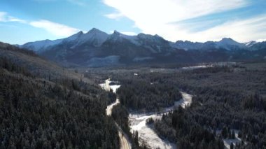Kış mevsiminde dağlık yol ve kamyonet manzarası. Tatra dağlarında destansı, karlı beyaz kış. Yüksek kayalık dağlar ve temiz yol Polonya 'dan Slovakya' ya uzanan donmuş ormandan geçiyor.