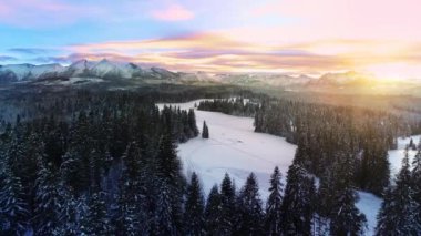 Kışın karla kaplı dağlar, hava manzarası. Kışlık dağ manzarası ve renkli günbatımı gökyüzü. Tatra yüksek dağları ve bozulmamış büyülü manzaralar.