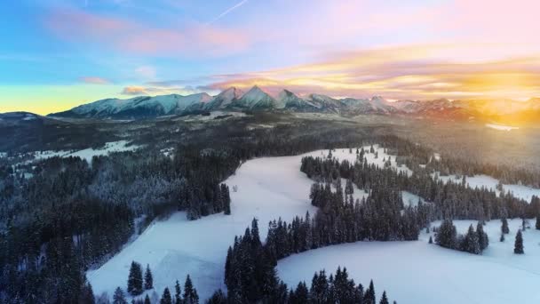 雪の冬には山のキャップ 空中ビュー 冬の山の風景とカラフルな夕日の空の空中ビュー タトラの高い山と魔法のように手付かずの風景 — ストック動画
