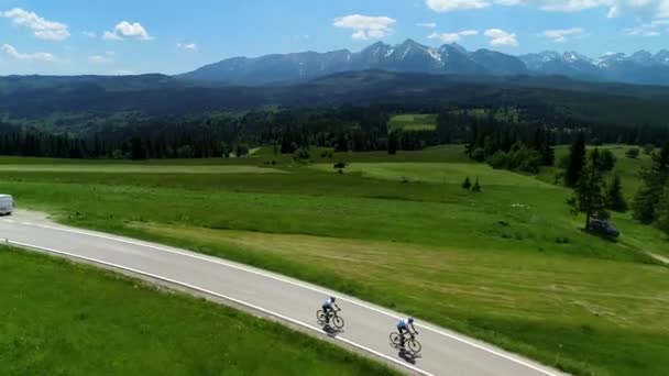 山の空の道路と2つの自転車サイクリングの空中ビュー 山の広い範囲と壮大な高山の景色を背景に コンセプト 山の中の休暇 自転車で旅行 — ストック動画