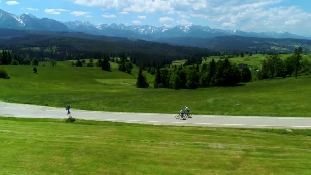 Vista Aerea Montagna Strada Vuota Due Ciclisti Bicicletta Sullo Sfondo — Video Stock