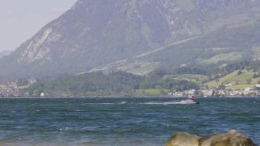 Uçurtma. Dalgalara atlayıp İsviçre Alplerinde bir gölde sörf yapan sörfçüler. Sarnersee, Sarnen Gölü, Obwalden Kantonu, İsviçre