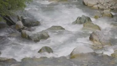 Taşların etrafında akan su. Dağlarda bir dere. Schchental Vadisi, Canton Uri, İsviçre. 