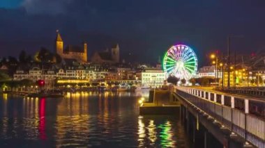 Zaman aşımı, gece dönme dolap. Ortaçağ Avrupa 'sında gölün yanındaki kasabada gözlem çarkı. Rapperswil-Jona, Canton St. Gallen, İsviçre.