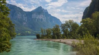 Göl kenarındaki dağları geçen bulutların zamanı. Çimenli dağ manzarası. Walensee, Walen Gölü, Canton Glarus, İsviçre. 