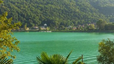 Zaman ayarlı, gölde tekne trafiği ve arka planda dağ. Lugano Gölü, Canton Ticino, İsviçre