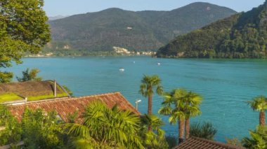 Zaman ayarlı, gölde tekne trafiği ve arka planda dağ. Lugano Gölü, Canton Ticino, İsviçre