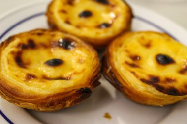 Tipik Portekiz kremalı turtaları, Pastel de Nata veya Pastel de Belem. Geleneksel kafede geleneksel Portekiz kremalı pastalarının yakın çekimi: Restoran. Pastel de nata. Pastis de Belem.