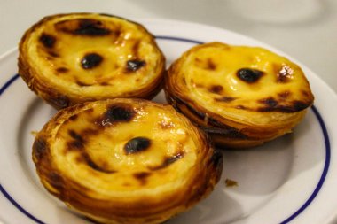 Tipik Portekiz kremalı turtaları, Pastel de Nata veya Pastel de Belem. Geleneksel kafede geleneksel Portekiz kremalı pastalarının yakın çekimi: Restoran. Pastel de nata. Pastis de Belem.