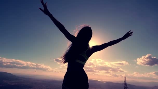 Mujer silueta en la cima de la montaña — Vídeos de Stock