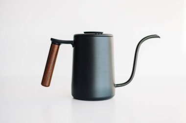 Siyah çelik çaydanlık kahve demlemek için üzerine dökülüyor..