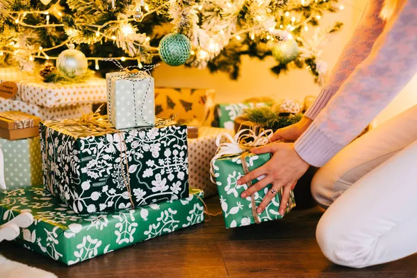 Young Woman Puts Present Christmas Tree While Sitting Floor Home —  Fotos de Stock