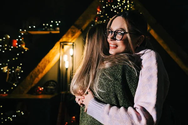 圣诞节或新年的庆祝活动中 两个年轻快乐的女人在圣诞树旁拥抱在一起 — 图库照片