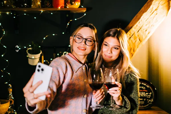 Δύο Νεαρές Χαρούμενες Γυναίκες Βγάζουν Εορταστική Φωτογραφία Κοντά Στο Χριστουγεννιάτικο — Φωτογραφία Αρχείου