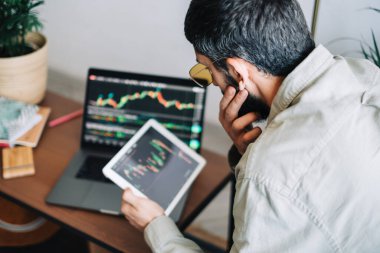 Kafkas işadamı çevrimiçi ticaret yapıyor, bilgisayar teknolojisi kullanıyor, borsa ticaretine bakıyor ve analiz ediyor.