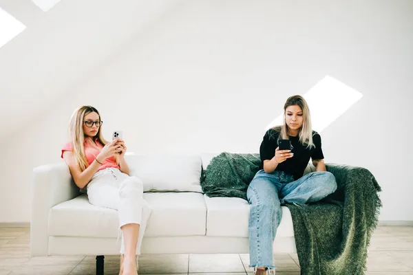 Dos Mujeres Sentadas Sofá Sala Estar Uso Teléfonos Móviles Navegar — Foto de Stock