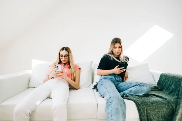 Dua Wanita Duduk Sofa Ruang Tamu Dan Menggunakan Ponsel Menjelajahi — Stok Foto