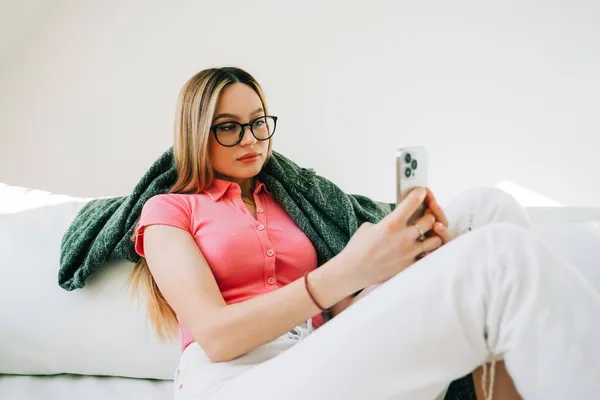 Mujer Joven Caucásica Usando Teléfono Inteligente Mientras Descansa Sofá Casa — Foto de Stock