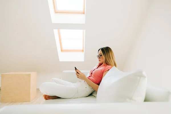 Mujer Joven Caucásica Usando Teléfono Inteligente Mientras Descansa Sofá Moderna — Foto de Stock