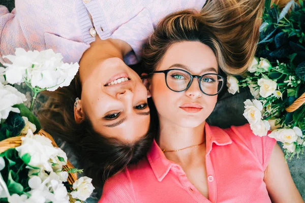 Retrato Duas Mulheres Caucasianas Atraentes Deitadas Chão Com Flores Vista — Fotografia de Stock