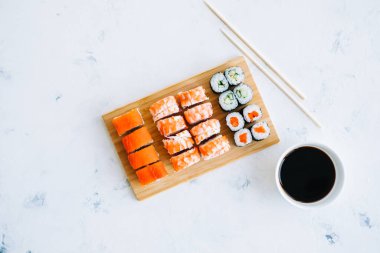 Bambu tahtasında suşi ruloları, Philadelphia, karidesler ve soya soslu maki, Japon yemekleri..