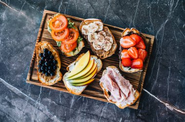 Kahvaltı, öğle yemeği ya da atıştırmalık için lezzetli sağlıklı tostlar, koyu mermer arka plan.